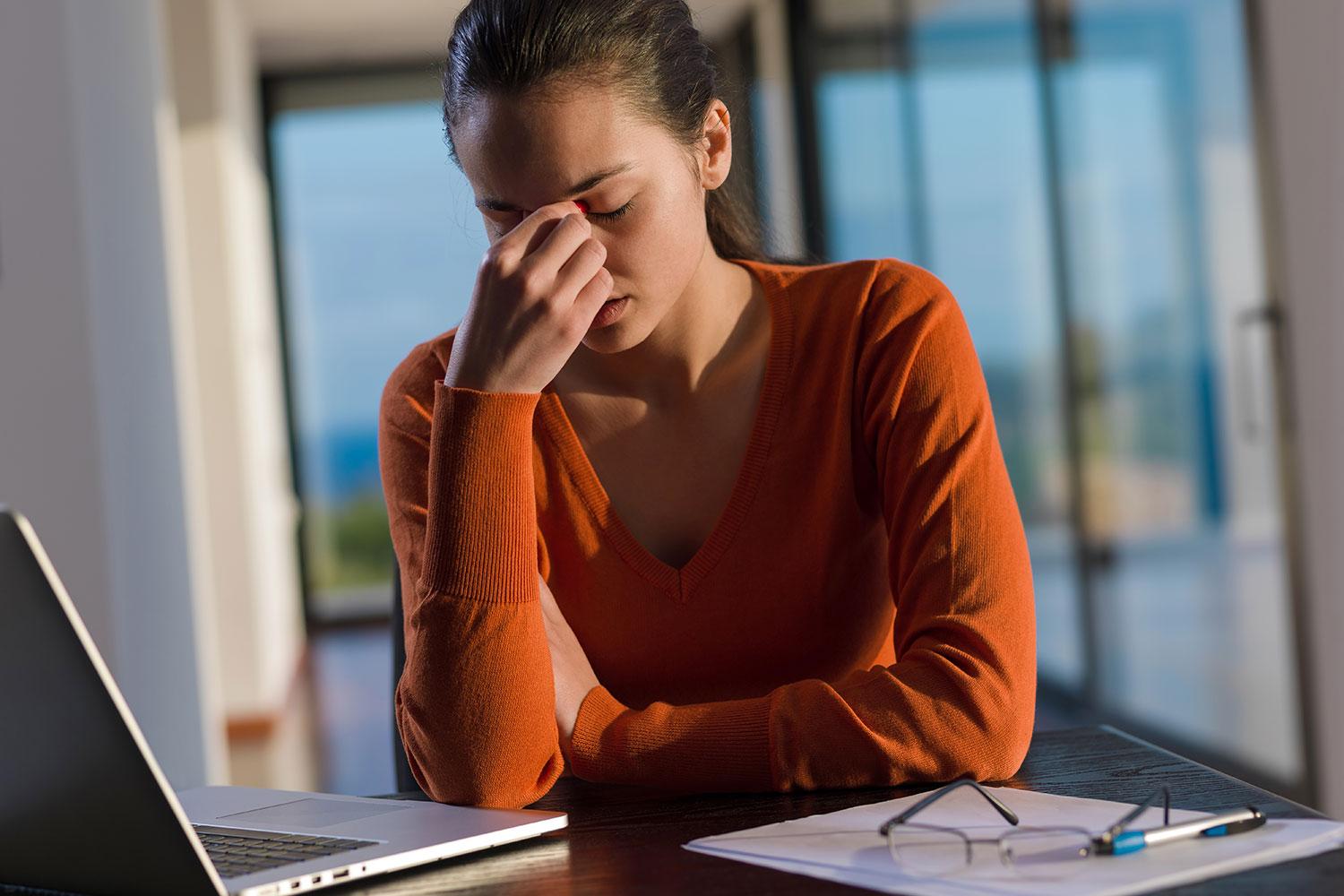 Person suffering from eye strain looking at a screen.