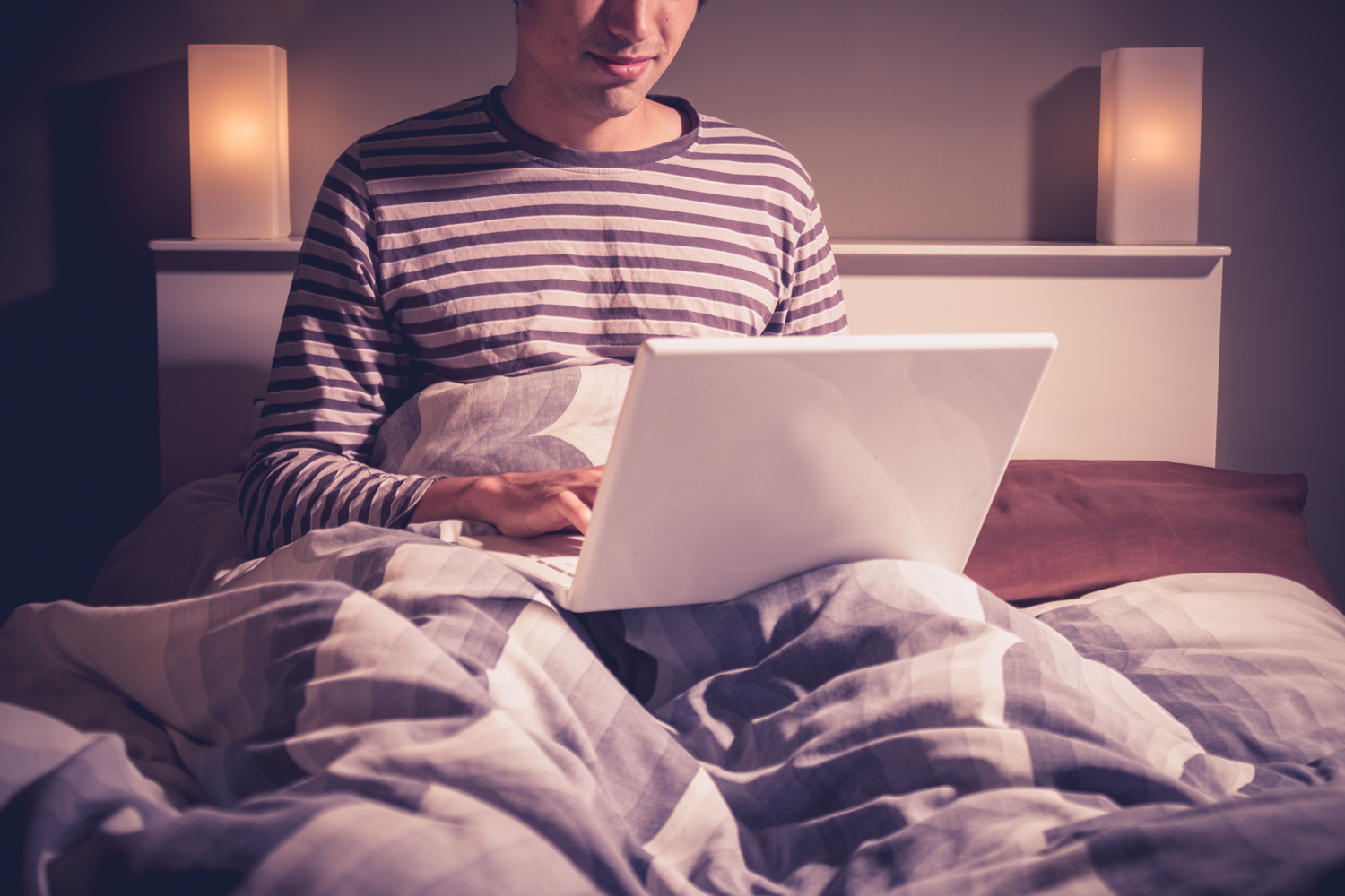 A person using a computer in bed.