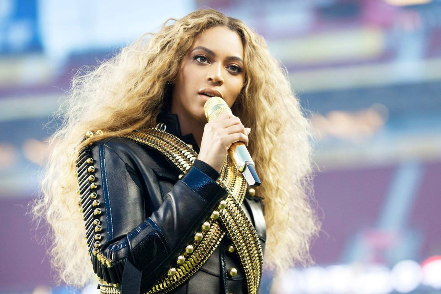 Beyonce holds a mic and sings.