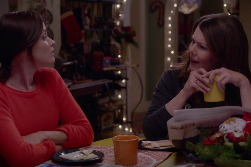 A mother and daughter sit down at a table and talk.