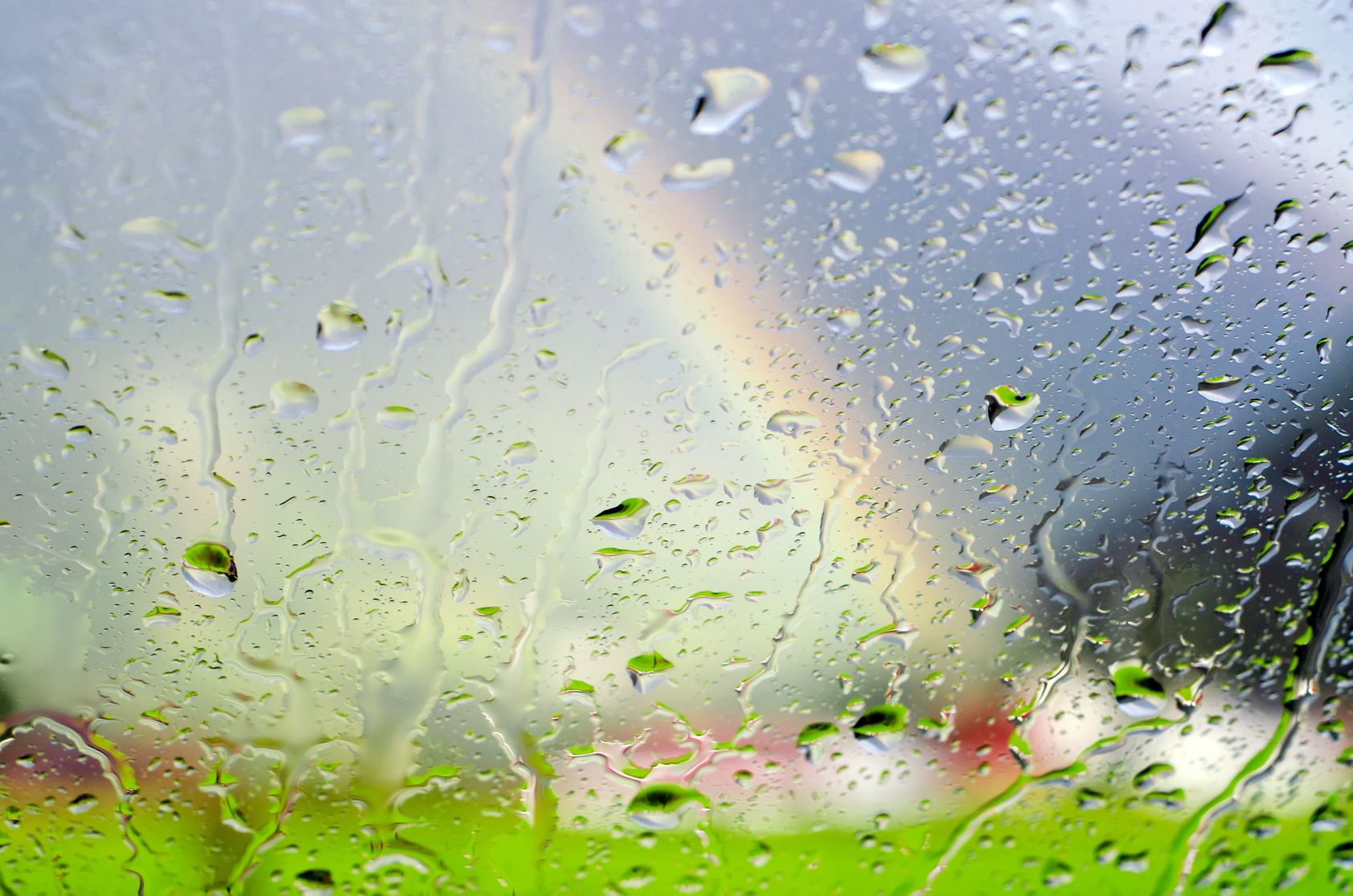 high humidity weakens radio signals lte raindrops on glass panel with scenery and rainbow in background