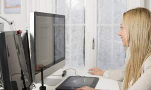 A person working at a computer with two monitors.