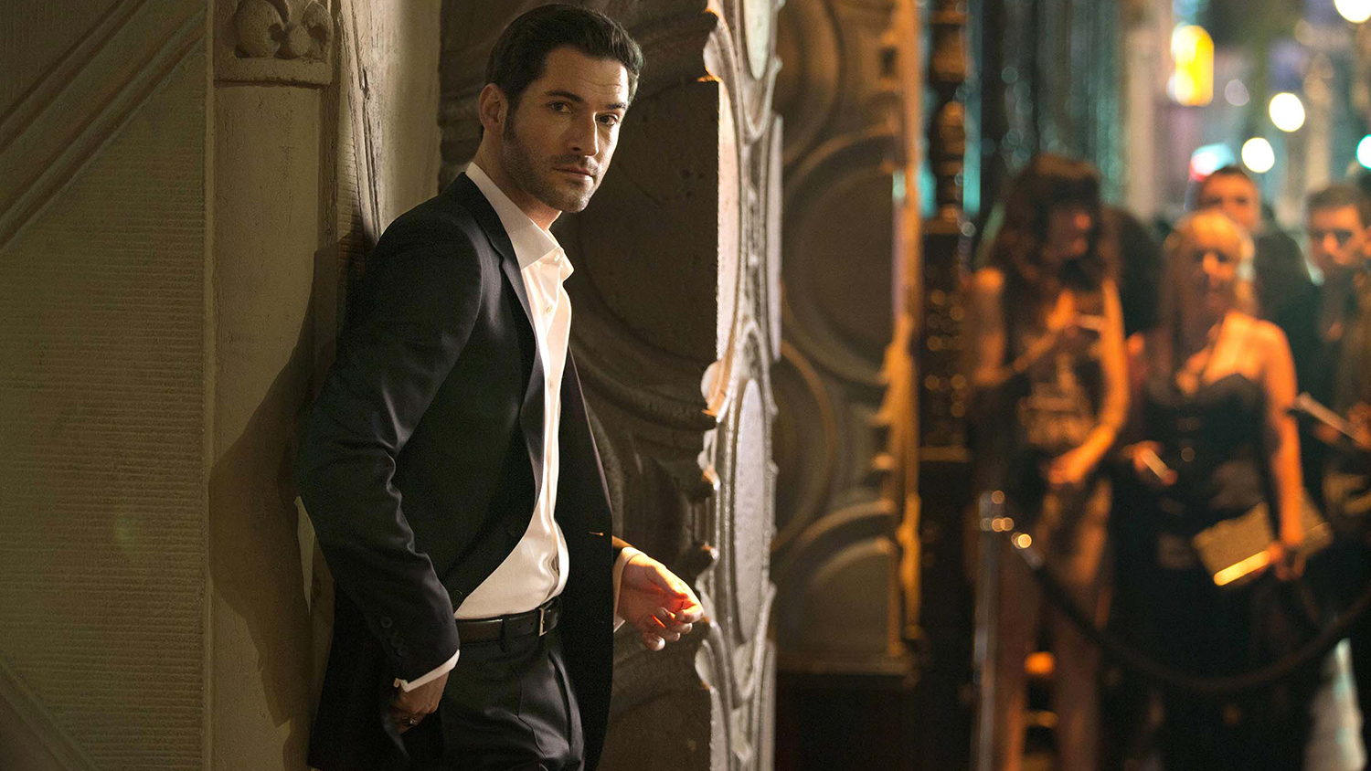 Tom Ellis as Lucifer, leaning against an archway.