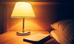 The Harth Sleep-Shift Light Bulb running next to a bed.