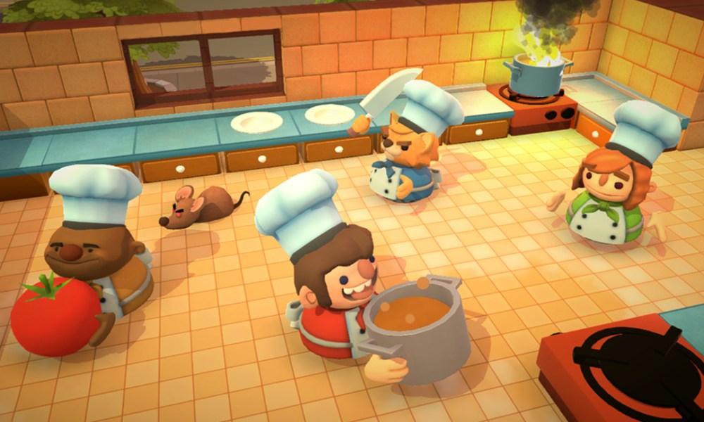 Four players work a chaotic kitchen in Overcooked.