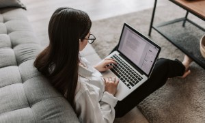 Woman sitting on the floor working at her laptop.