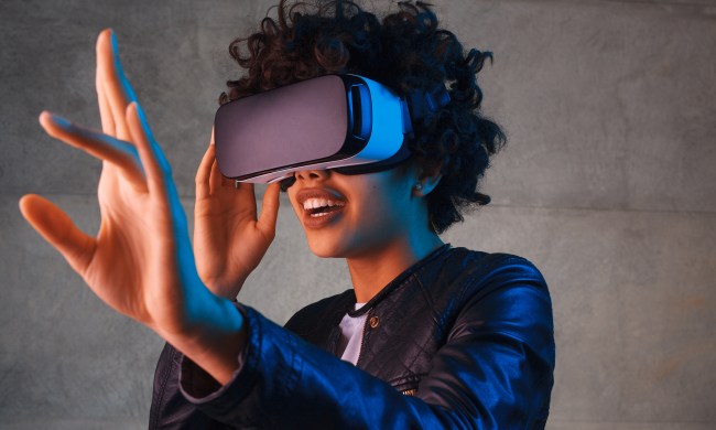 A woman reaching out while wearing a VR headset.