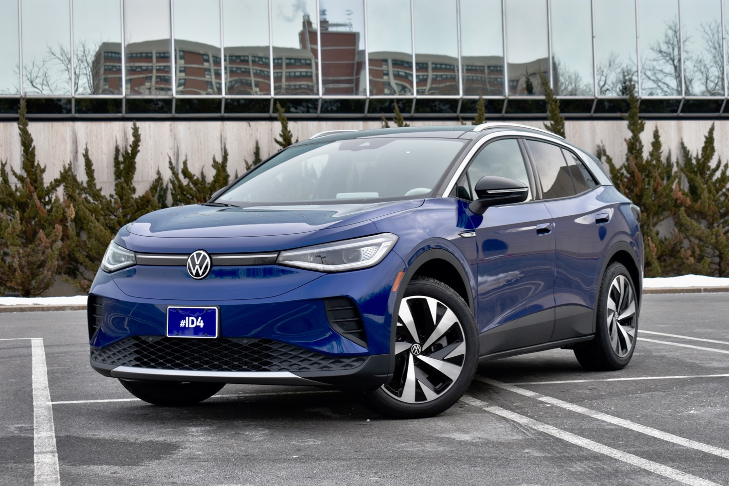 A blue 2021 Volkswagen ID.4 is parked diagonally in a parking lot.