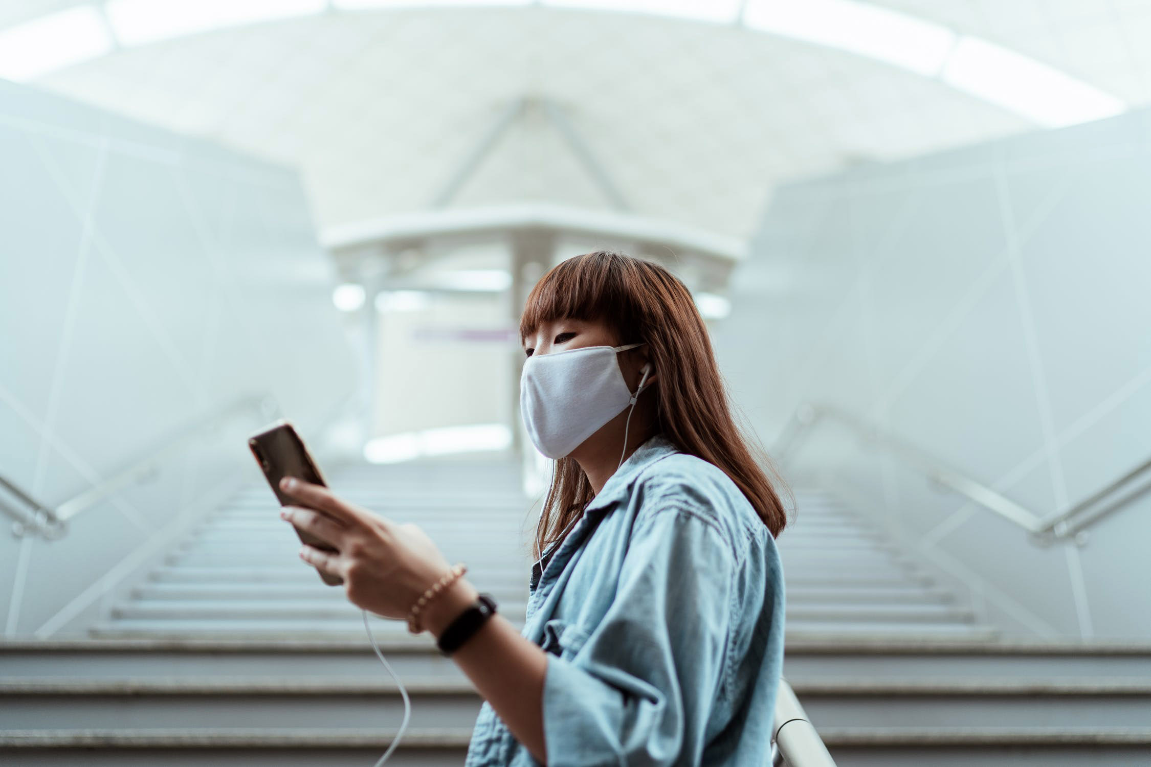 girl using phone with headphones