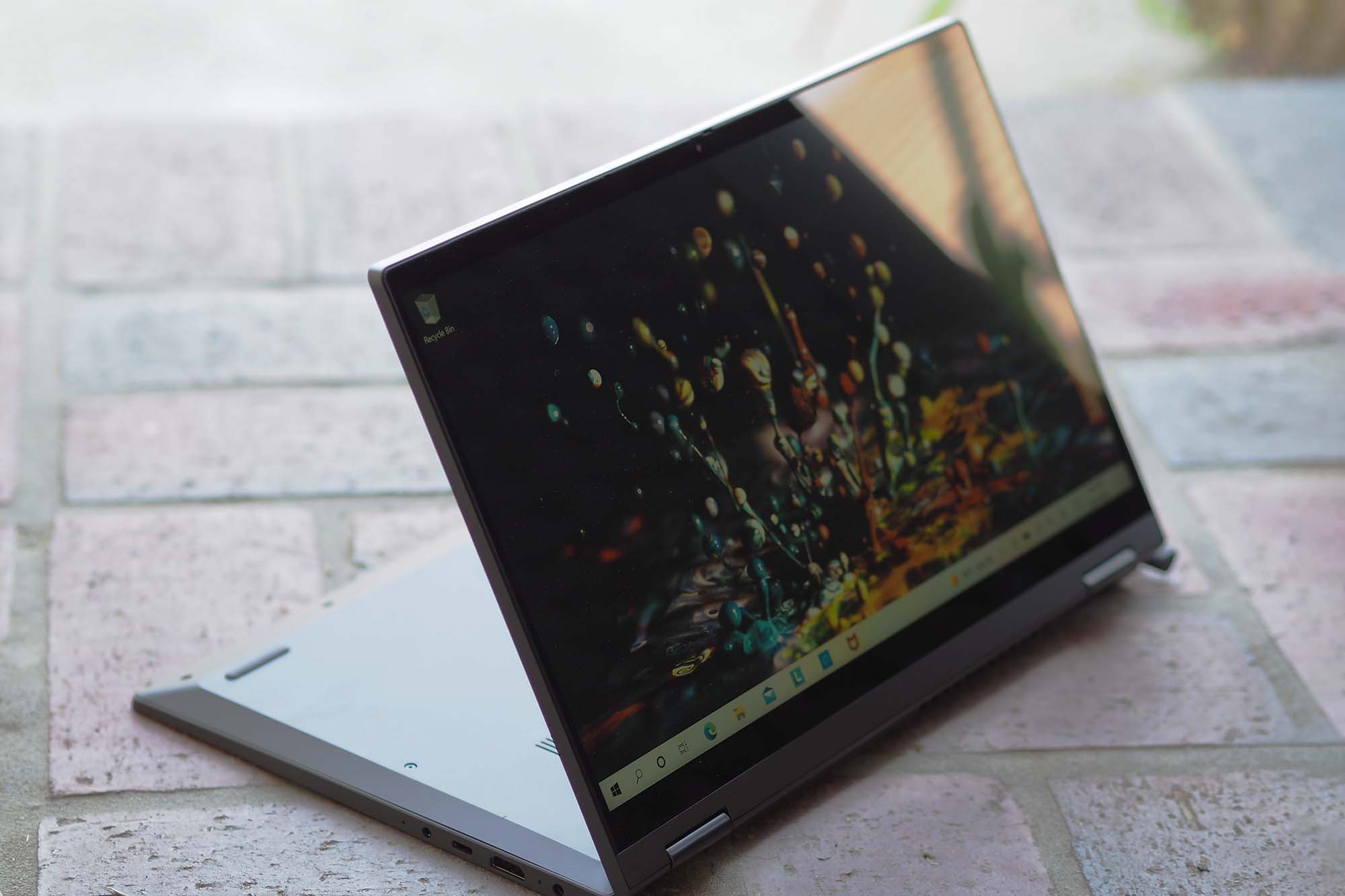 Image of the Lenovo IdeaPad Flex 5i 14 laptop folded backwards sitting on the ground.