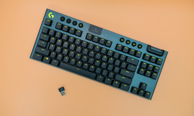 Logitech G915 TKL keyboard on an orange background.