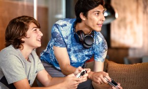 Teens with headphones playing video games.