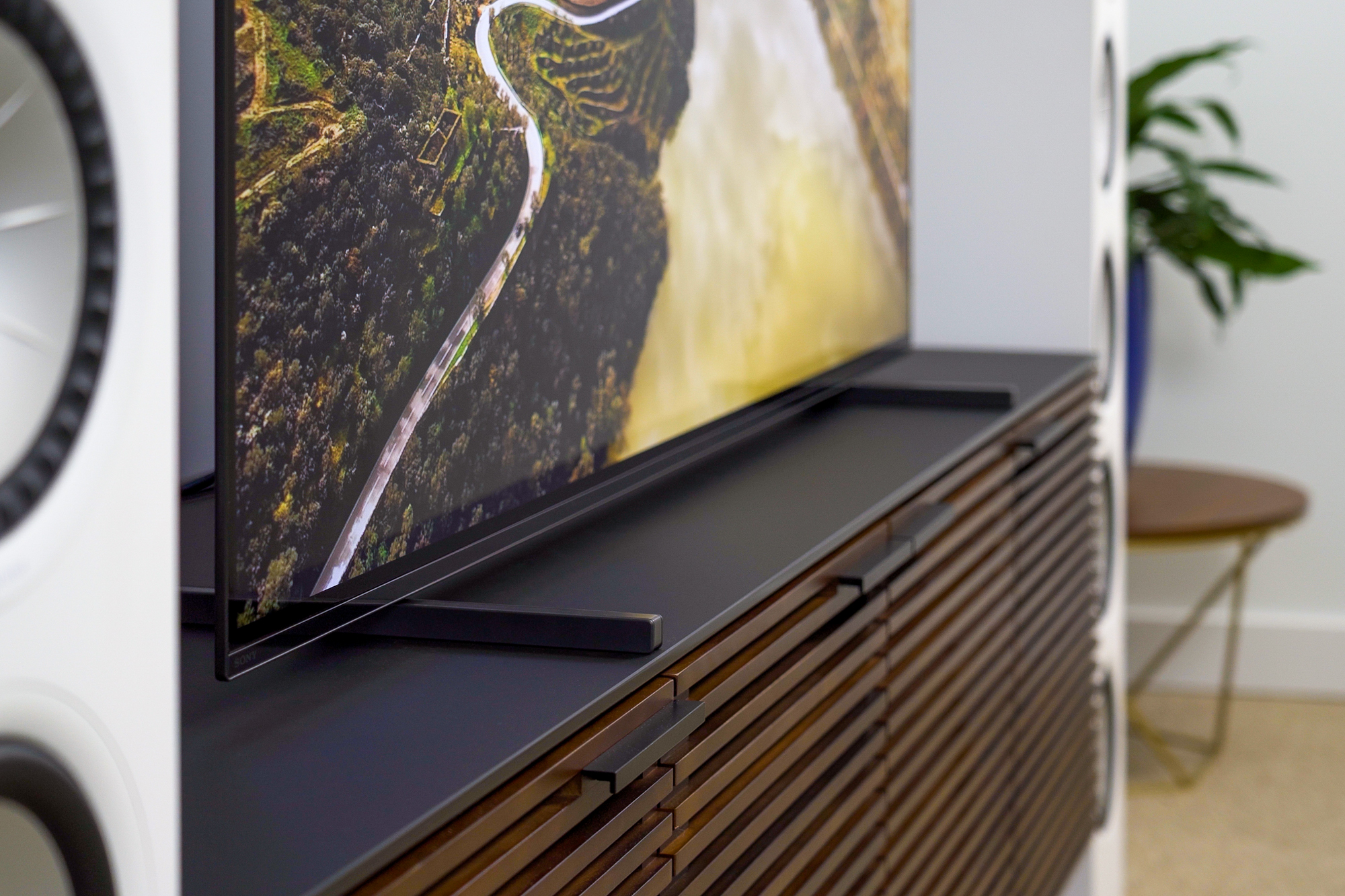 Sony A80J sitting on media console. Image is a closeup on the tv's stand.