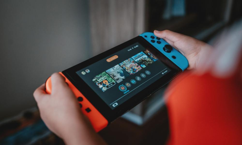 Person holding Nintendo Switch, looking at the home screen.