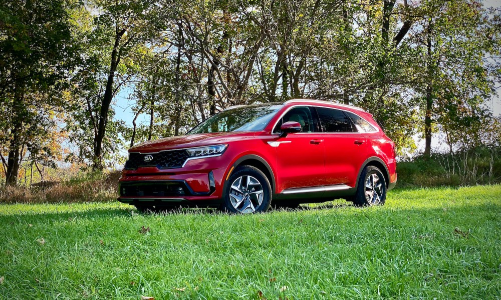 Front driver's side from an angle of the 2021 Kia Sorento Hybrid in a grassy field.