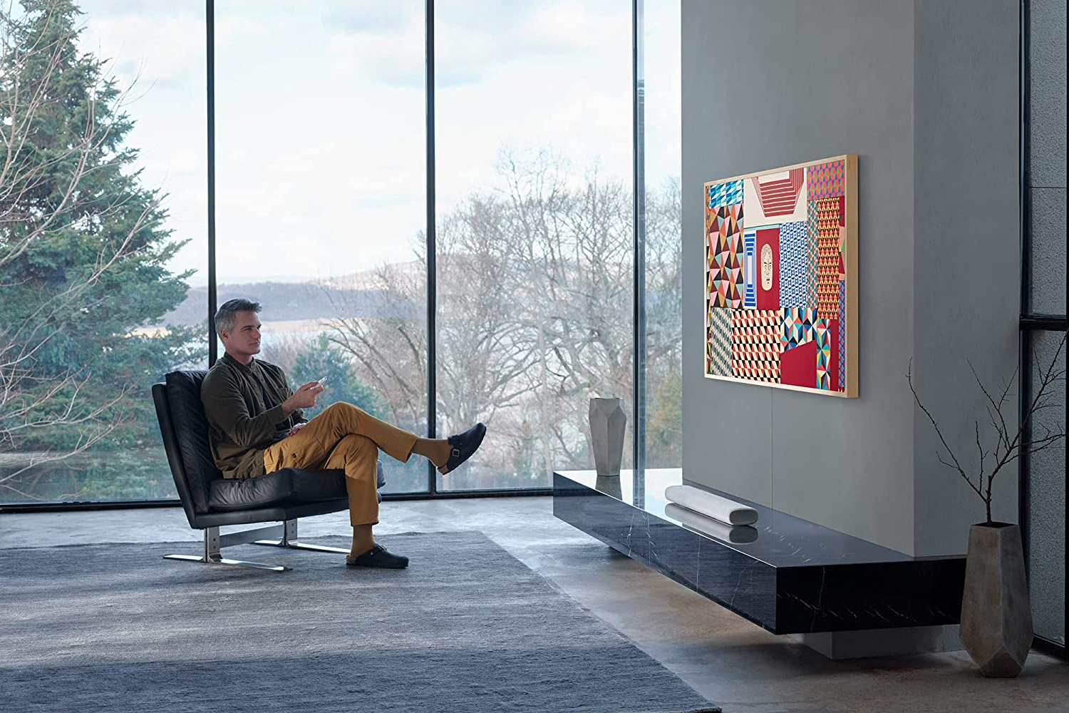 Man watching SAMSUNG 55-Inch Class Frame Series in living room.