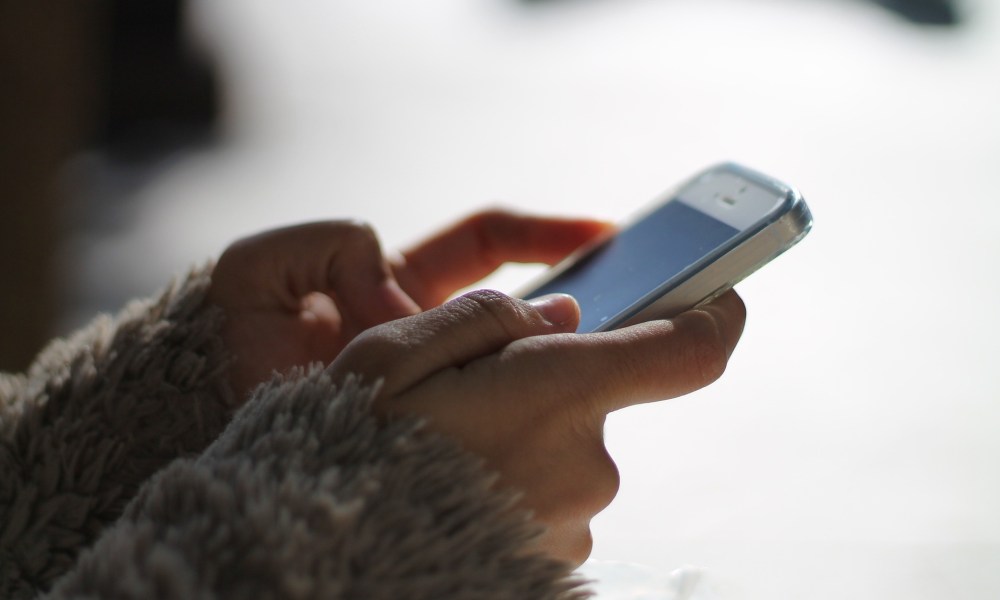 An image showing a women using her phone for messaging.