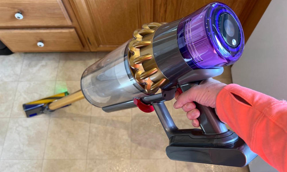 Dyson Outsize Absolute + being used on a kitchen floor.