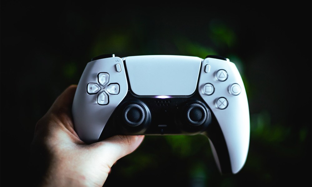 A person holds up a PS5 controller.