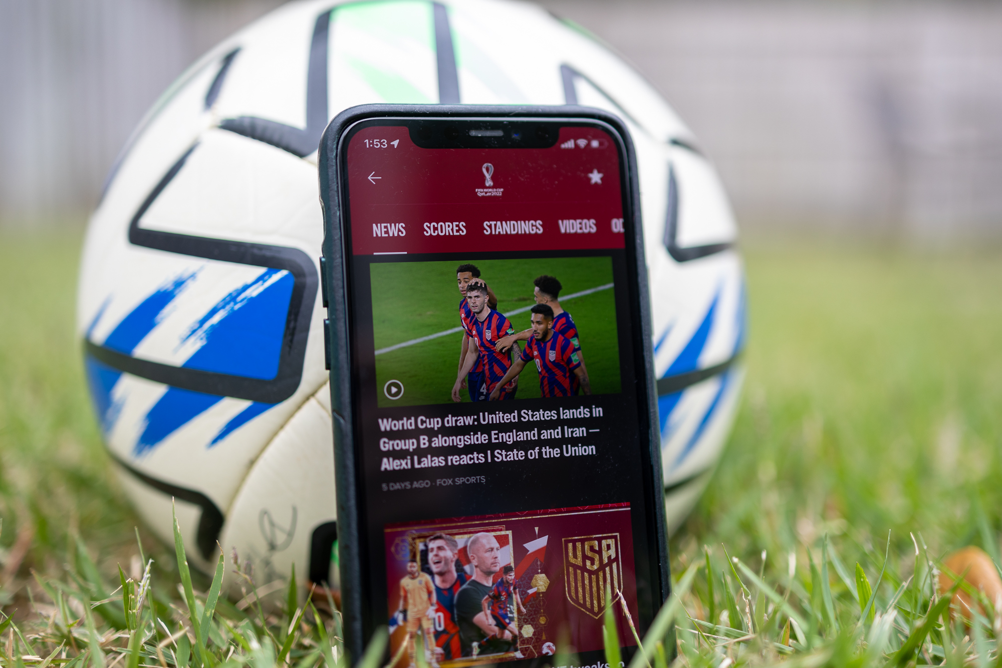 Fox Sports app on an iPhone in front of a soccer ball.