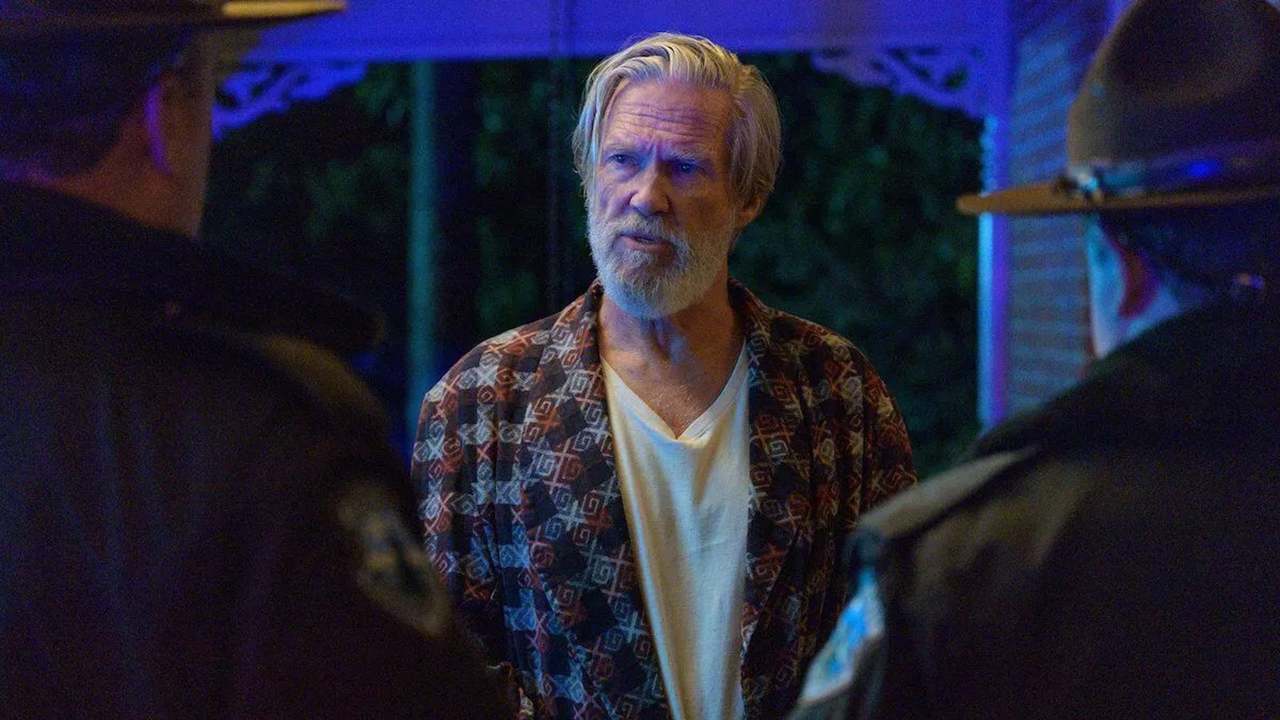 Jeff Bridges in The Old Man staring at two people at his doorstep.