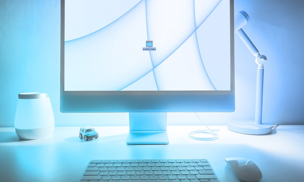 A new folder is created on a blue iMac desktop.