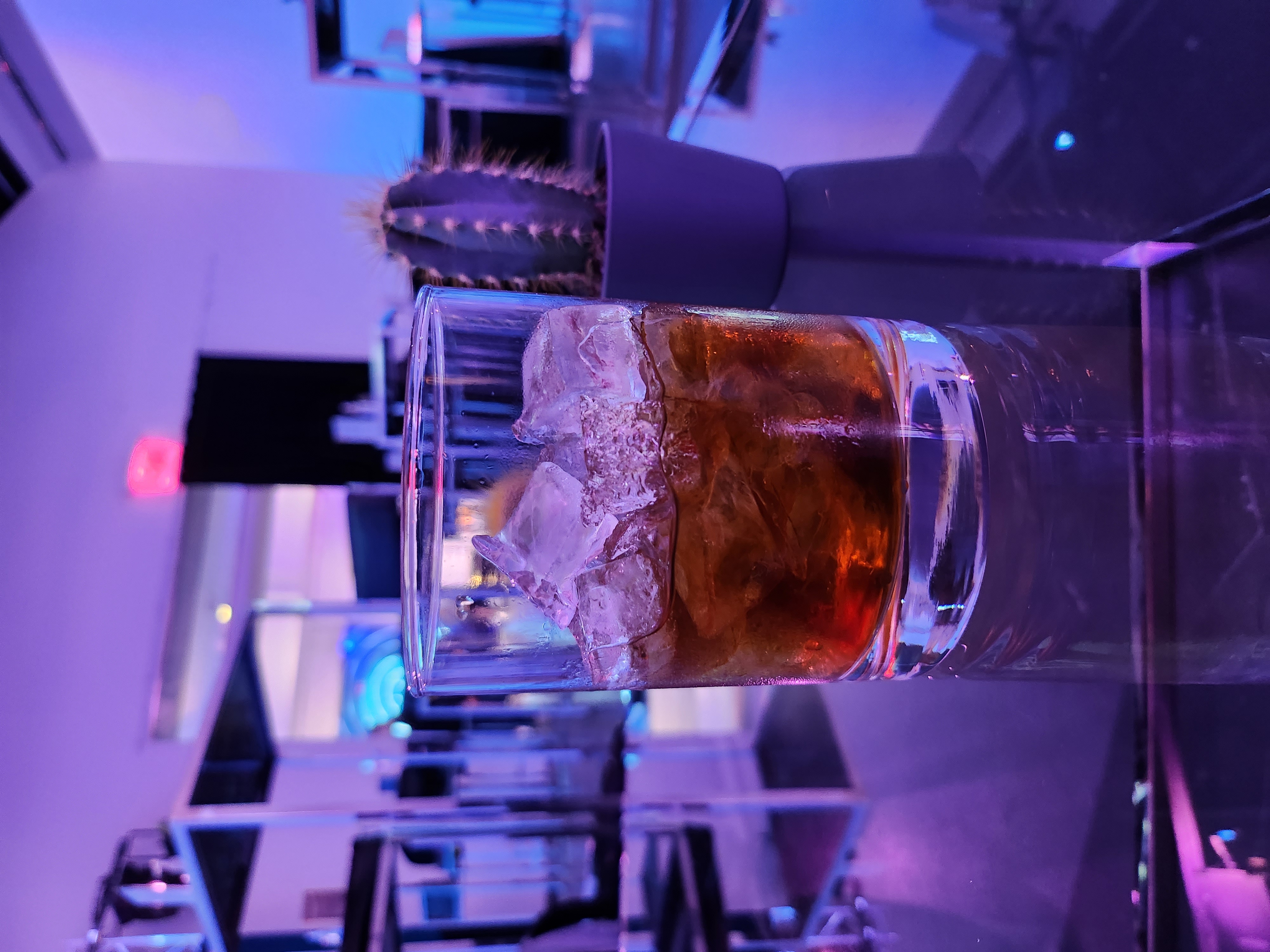 Photo of a whisky sour sitting on a glass table.