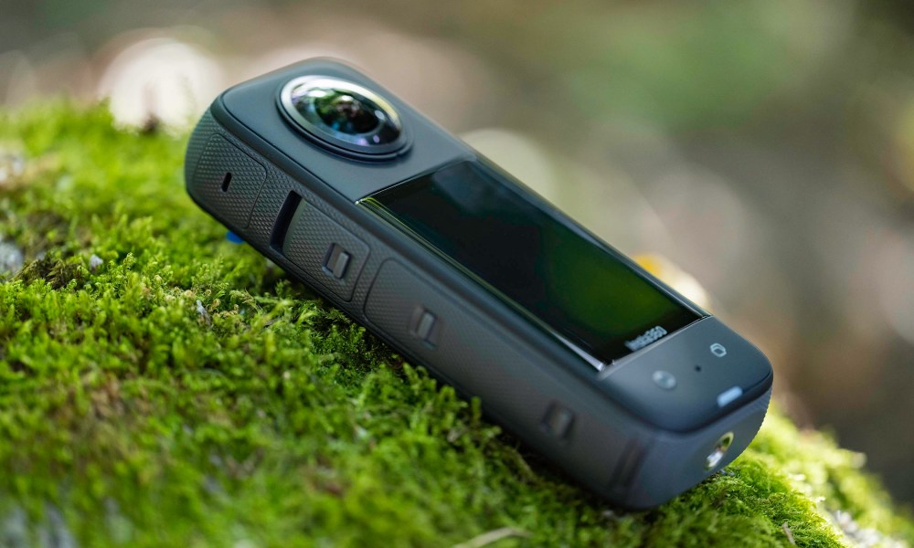 The Insta360 X3 on a moss covered rock.