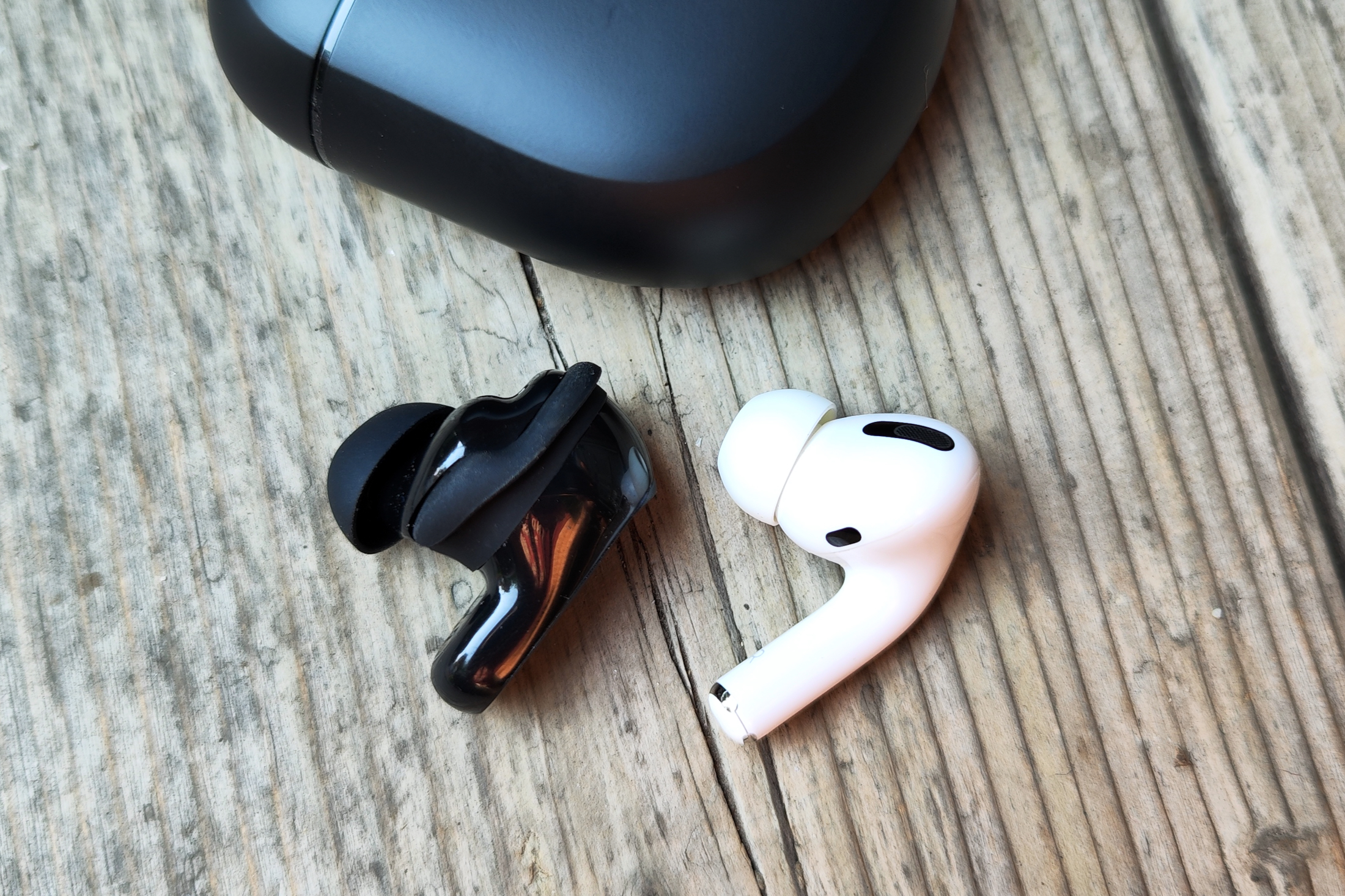 Bose QuietComfort Earbuds II seen next to first-gen Apple AirPods Pro.