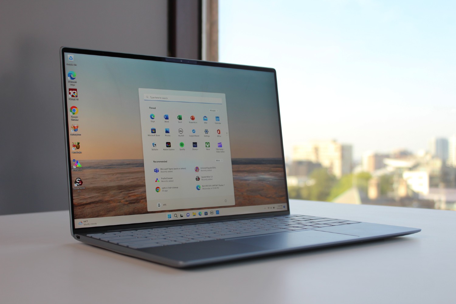 The Dell XPS 13 on a table with the Start Menu open.