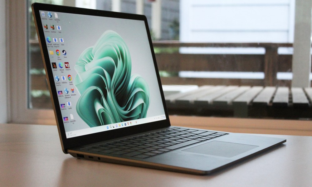 The Surface Laptop 5 on a table in front of a window.