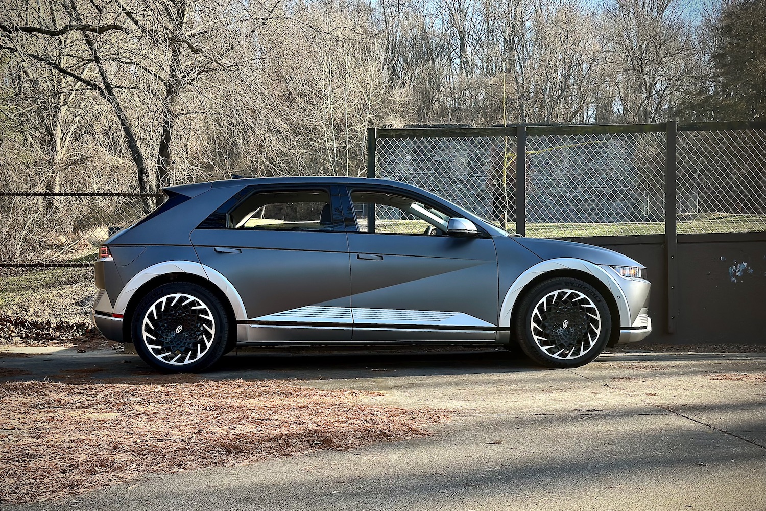 2022 Hyundai Ioniq 5 Limited AWD side profile in front of a chain fence.