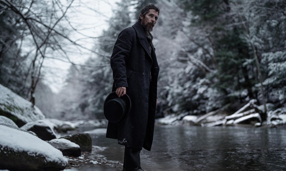 Christian Bale stands near a river in The Pale Blue Eye.