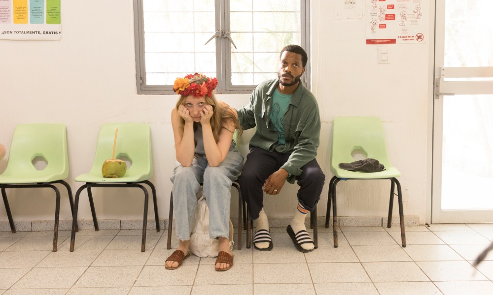 Anna Konkle and Jermaine Fowler sit in the waiting room of a hospital during a scene from The Drop.