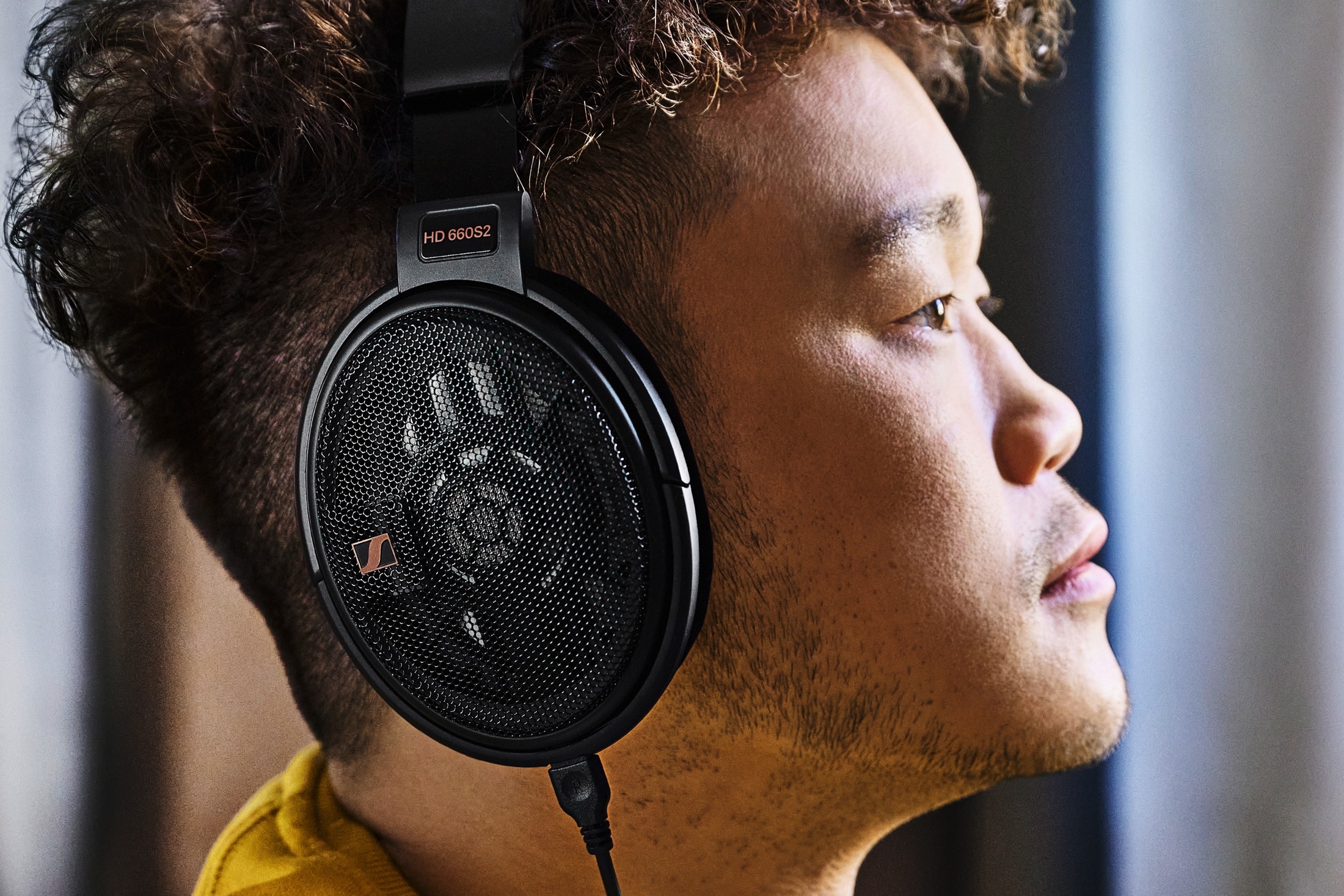 Man wearing Sennheiser HD 660S2 open-back headphones.