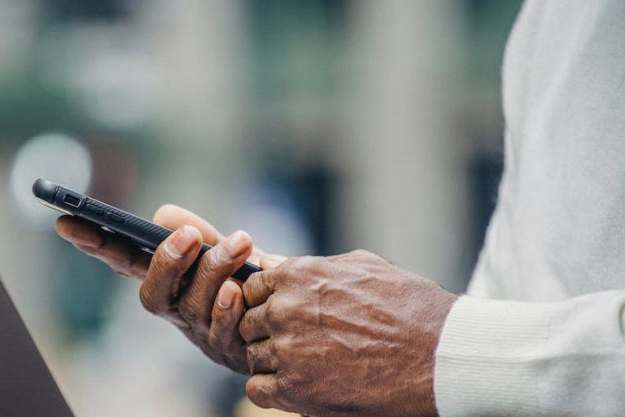 An elderly person holding a phone.