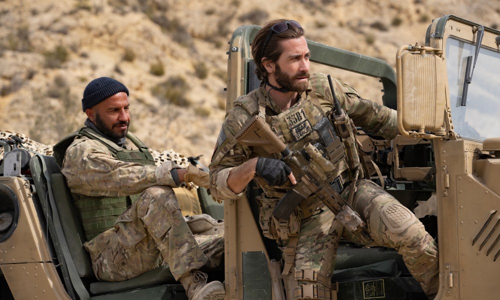 Dar Salim and Jake Gyllenhaal sit in a military Humvee together in The Covenant.