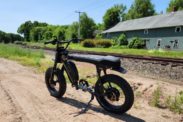 Super73-S Adventure parked by railroad tracks.