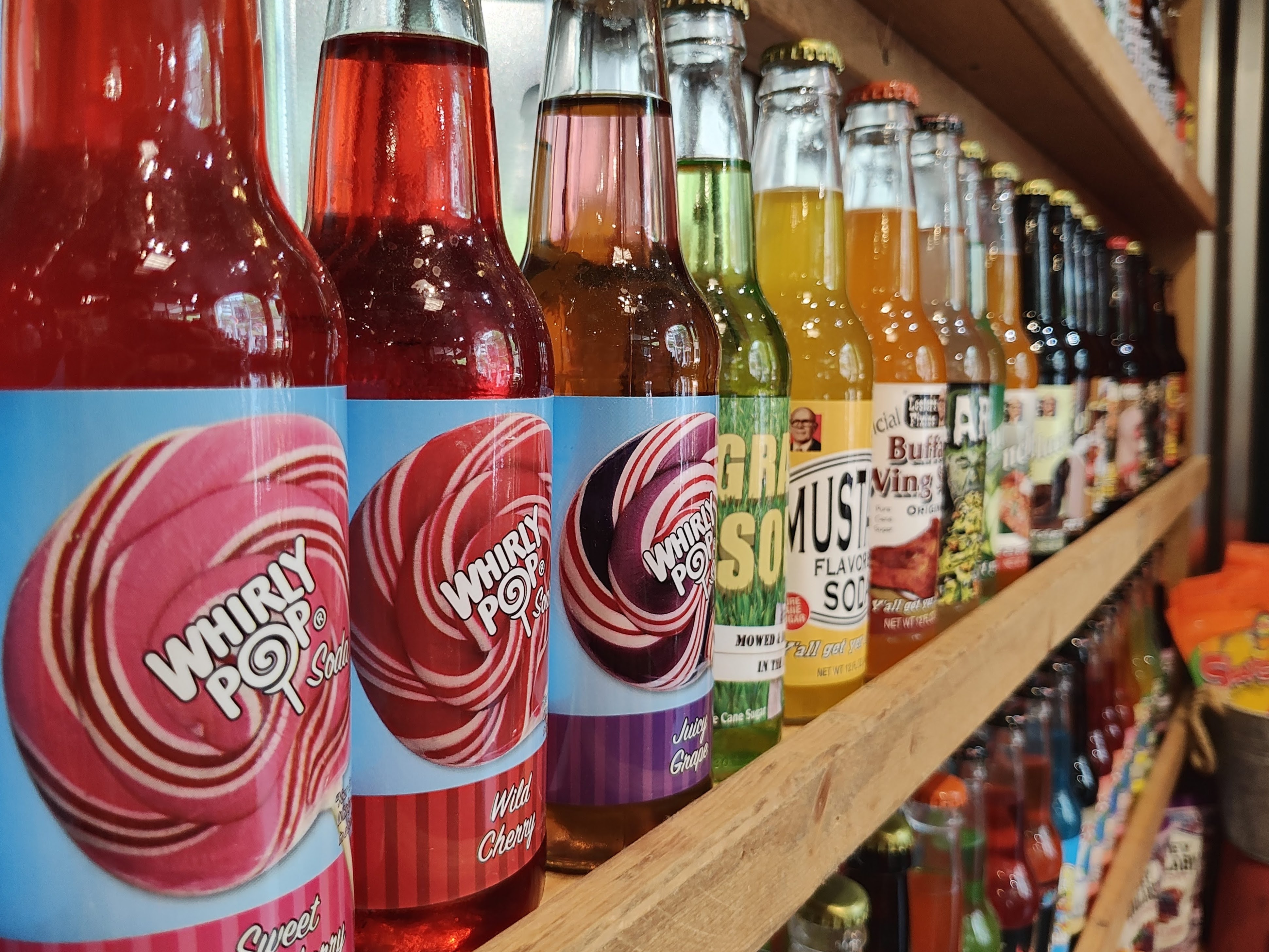 Glass soda bottles on a large shelf, taken with the Motorola Razr Plus.