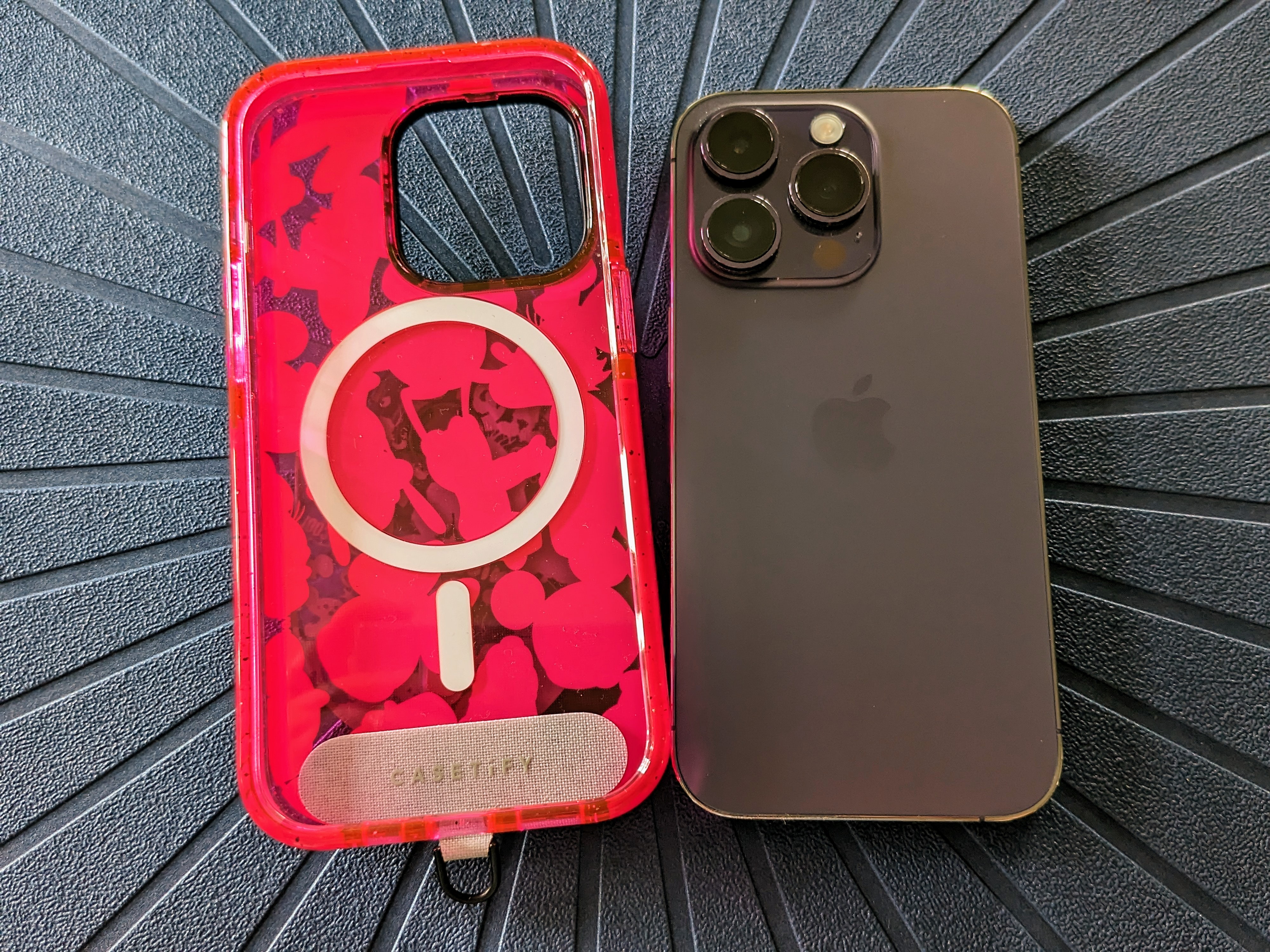 An iPhone 14 Pro case with Strap Card inserted next to an iPhone 14 Pro.