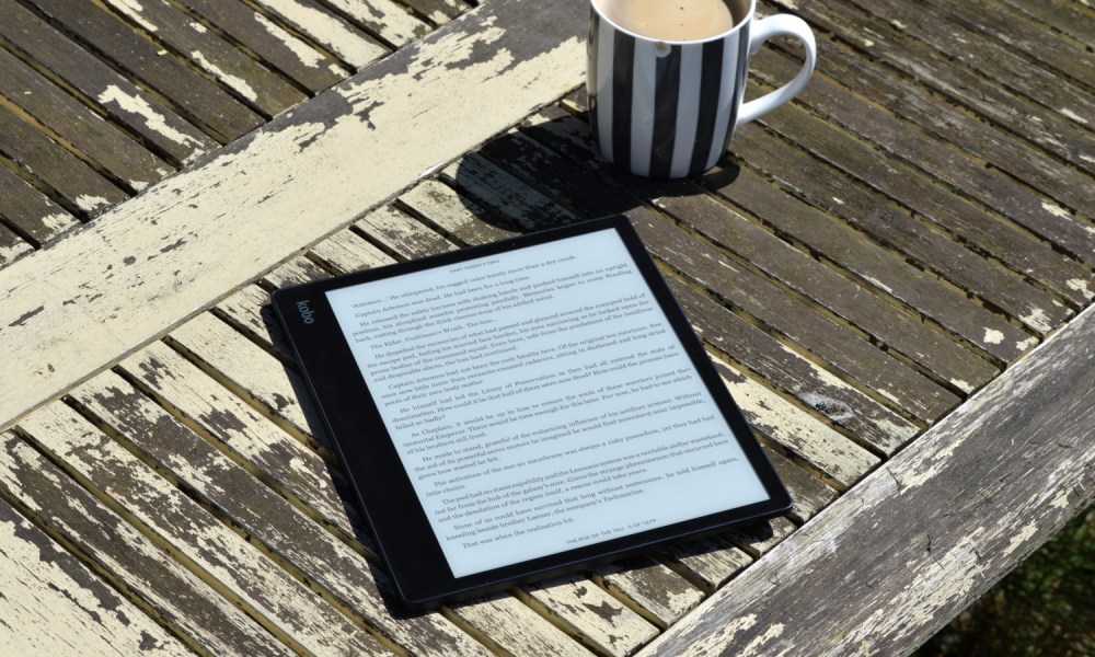 The Kobo Elipsa 2E laid outside on a table in the sun.