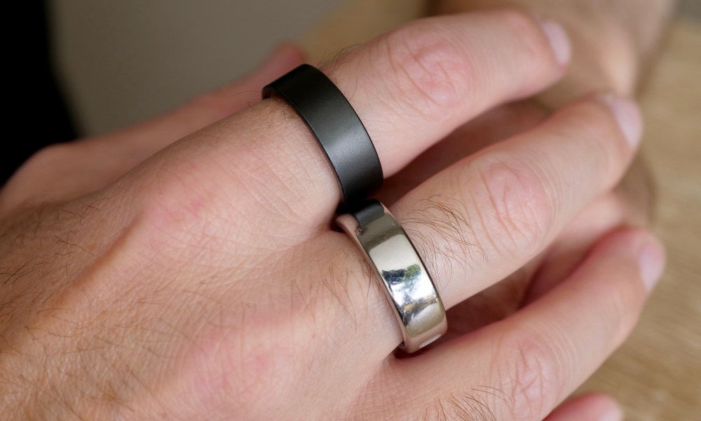 A person wearing the Ultrahuman Ring Air and the Oura Ring.