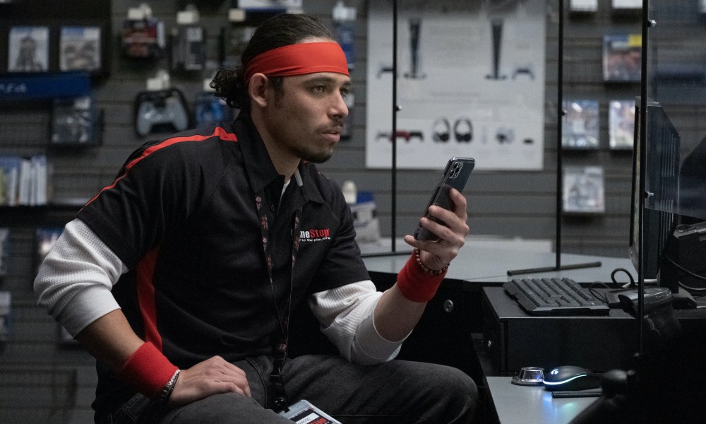 Anthony Ramos wears a GameStop uniform in Dumb Money.