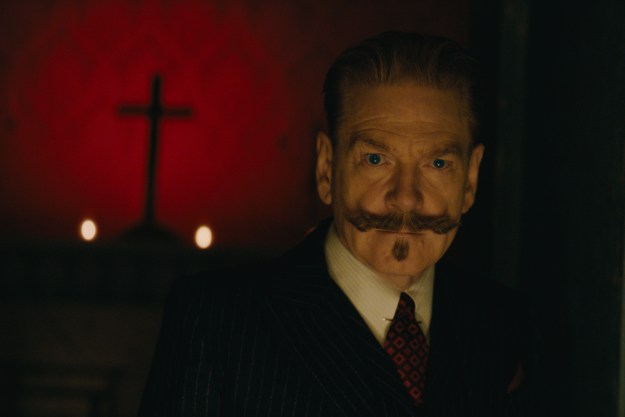 Hercule Poirot stands near a cross in A Haunting in Venice.