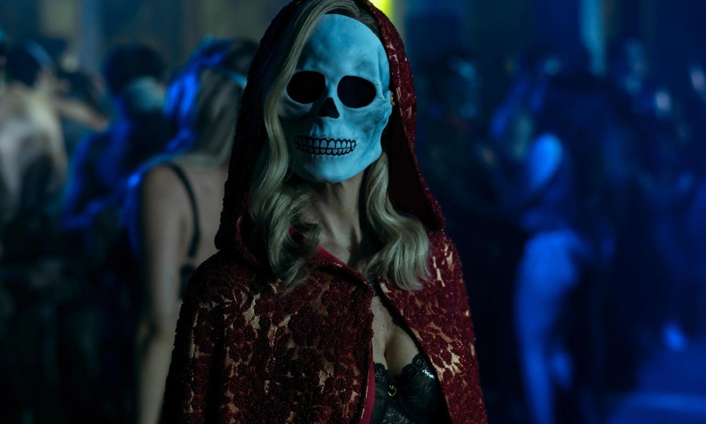 A blonde-haired woman wears a skull mask in The Fall of the House of Usher.