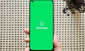 WhatsApp logo on a phone held in hand.