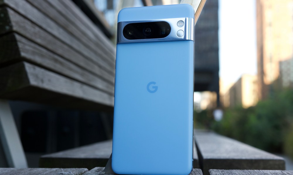 The Google Pixel 8 Pro sitting upright on a park bench.