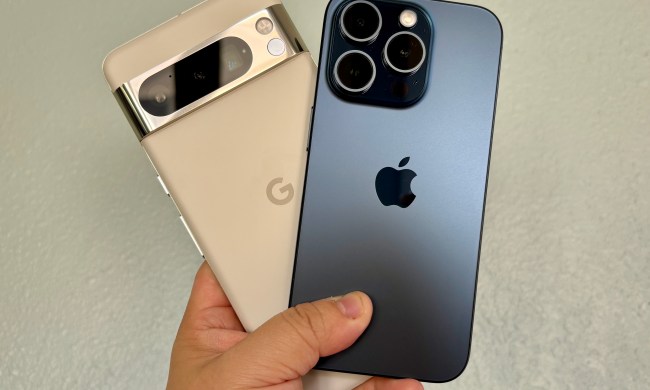 A Google Pixel 8 Pro in Porcelain (left) with an iPhone 15 Pro in Blue Titanium held in hand.