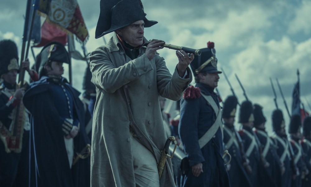 Joaquin Phoenix holds a spyglass in Napoleon.