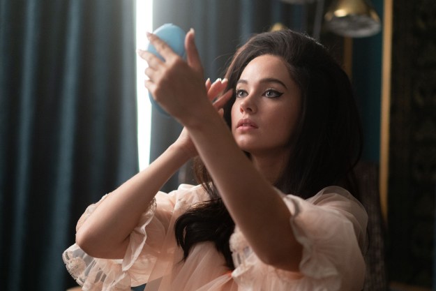 Cailee Spaeny applies makeup with a hand mirror.